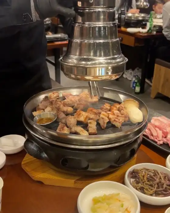 테이블 중앙에서 맛있게 구워지는 삼겹살과 목살