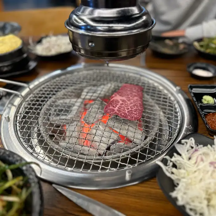 숯불 위에서 구워지는 한 점의 한우