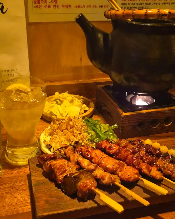 숯불 꼬치와 술이 놓인 테이블