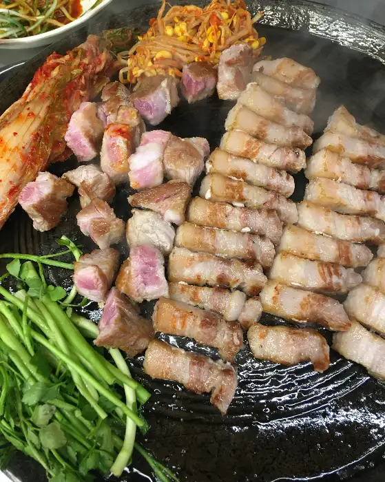 잘 익은 삼겹살 조각과 콩나물, 김치