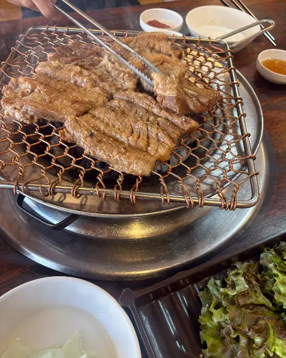 정성스럽게 숯불에 굽고 있는 돼지갈비
