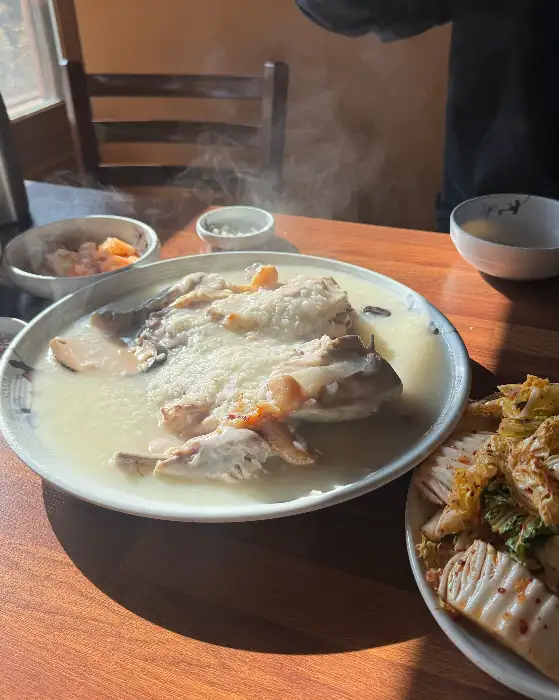 먹음직스럽게 차려진 닭백숙과 곁들임 반찬