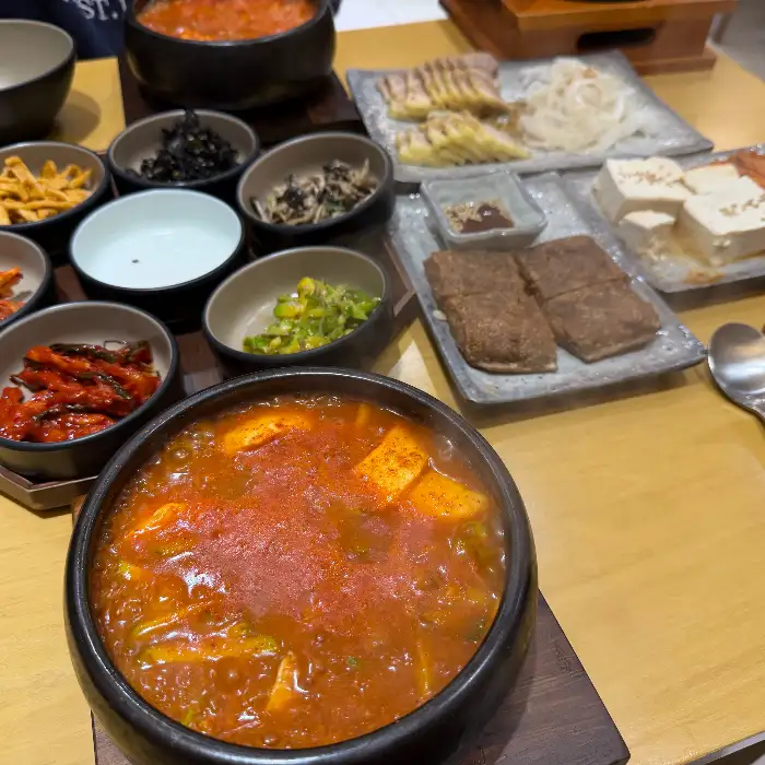 푸짐하게 담긴 고기 순두부찌개와 다양한 밑반찬