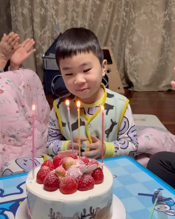 생일 케이크 앞에서 환하게 웃고 있는 아이