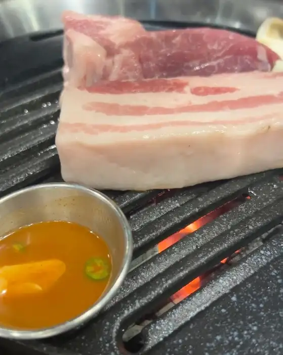 직접 구워지는 두툼한 삼겹살 덩어리