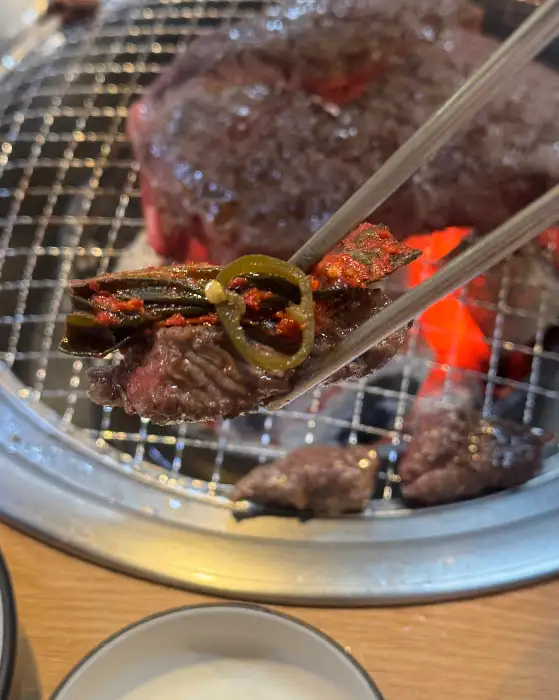집게로 집은 고기와 고추 조각