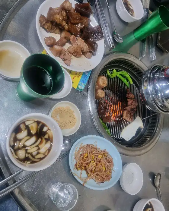 식탁에 차려진 반찬들과 숯불구이 판.