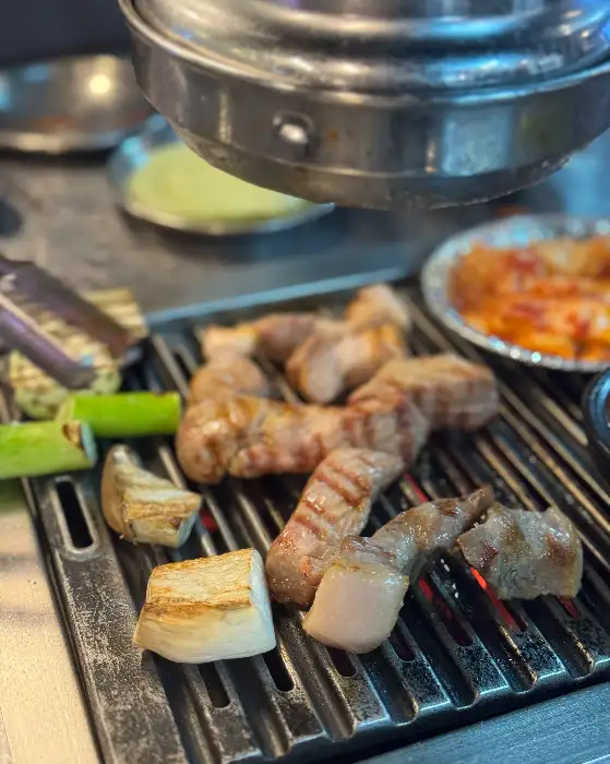 노릇하게 구워진 고기와 쌈 채소