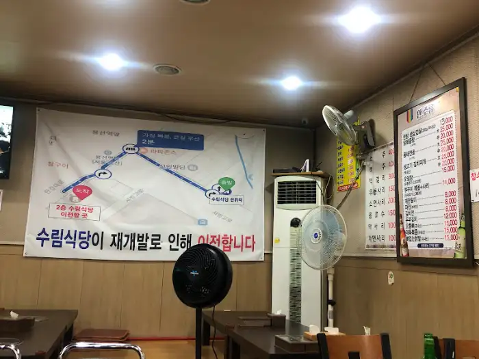 가게 내부를 비추는 모습, 벽에 메뉴판과 지도가 붙어있다.