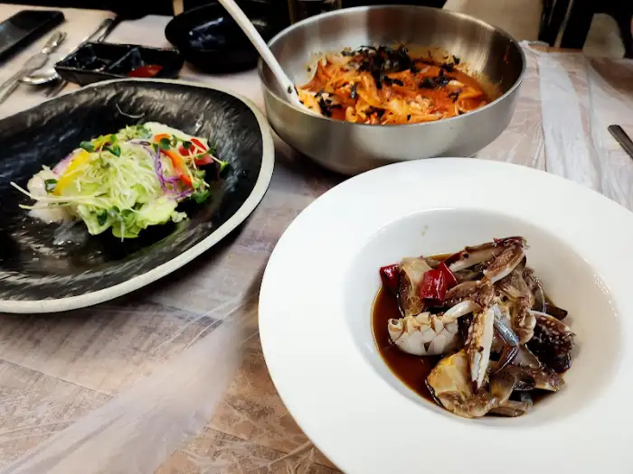 게장, 샐러드, 그리고 볶음 요리가 담긴 그릇