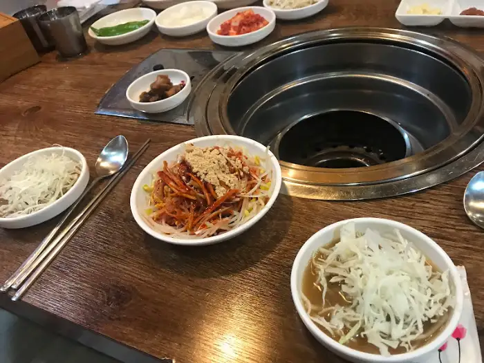 테이블에 놓인 숯불과 준비된 밑반찬들