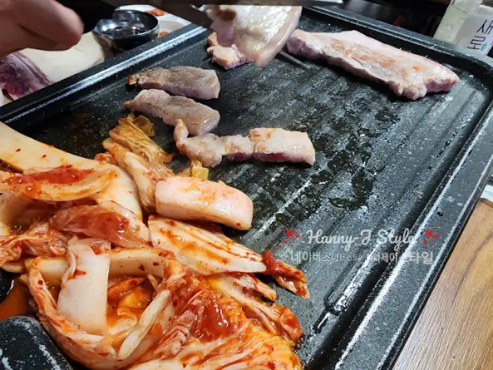 불판 위에 김치와 고기가 구워지고 있는 모습