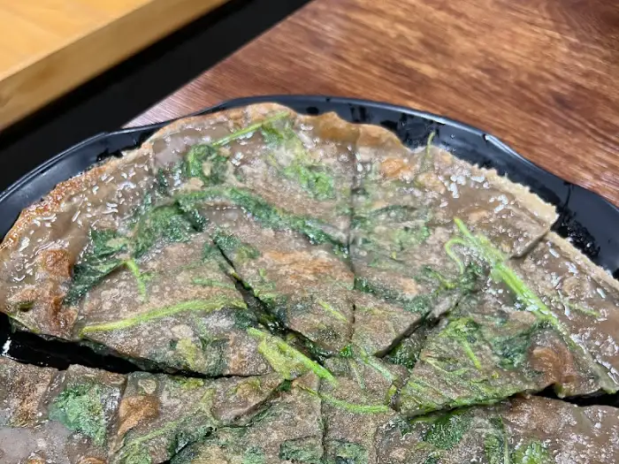 갓 부쳐 나온 메밀전의 노릇한 겉면과 푸릇한 채소