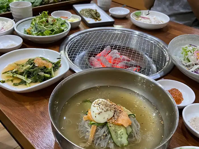 불판 위에 구워지는 고기와 냉면