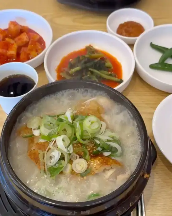 김이 모락모락 나는 누룽지 삼계탕과 밑반찬들