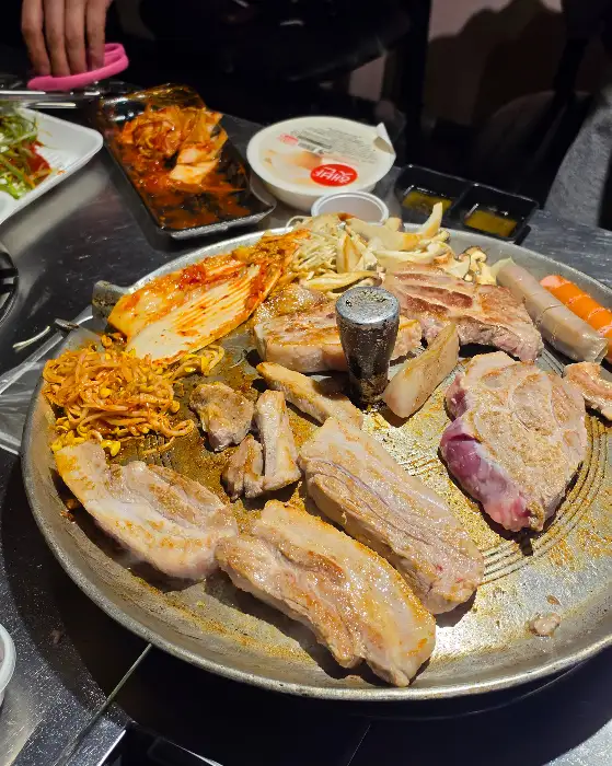 다양한 밑반찬과 고기가 함께 차려진 솥뚜껑