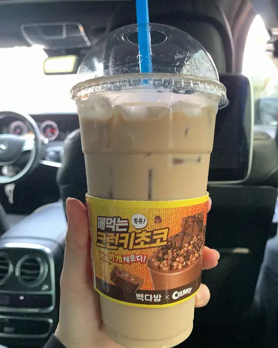 손에 들린 아이스 바닐라 라떼 컵