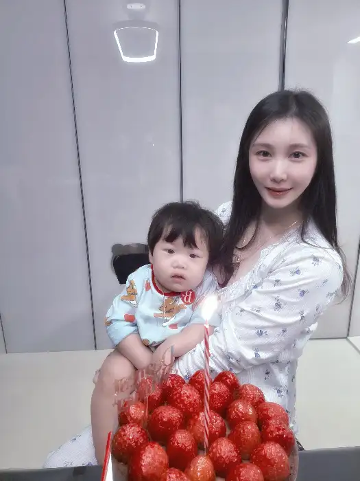 엄마 품에 안겨 케이크를 바라보는 아이