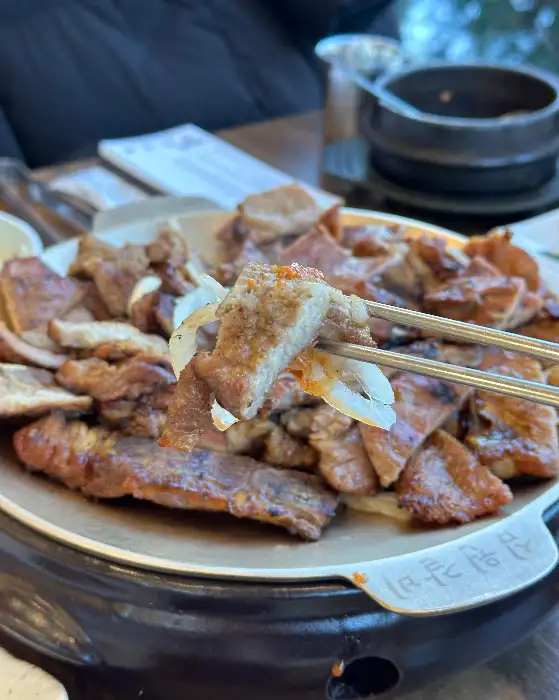 집게로 집어 올린 갈비 조각