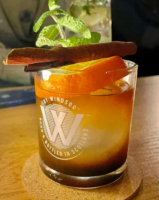 오렌지 슬라이스와 시나몬 스틱으로 장식된 칵테일