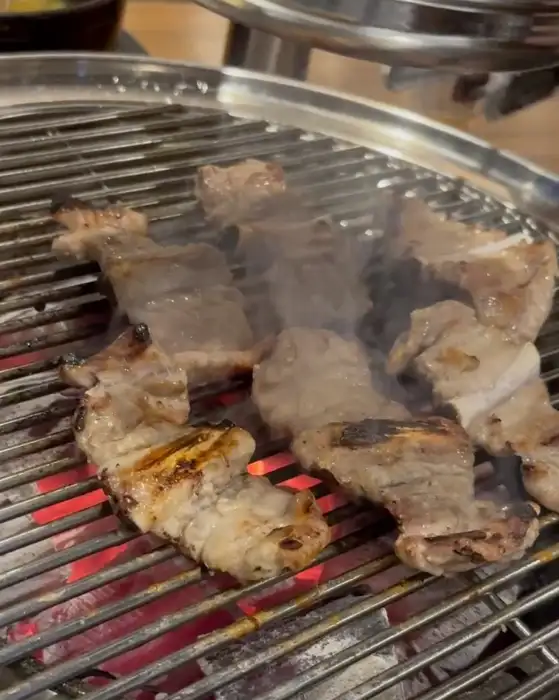잘 익은 돼지고기가 숯불 위에서 연기를 내며 구워지는 모습