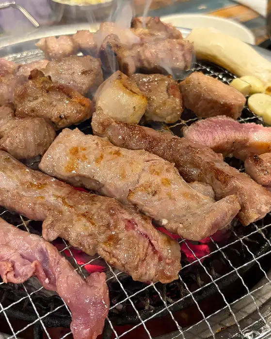 숯불 위에서 익어가는 다양한 부위의 고기
