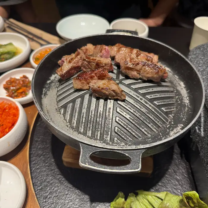 잘 구워진 소고기가 팬 위에 가지런히 놓여있습니다. 군침 도는 비주얼을 자랑합니다.