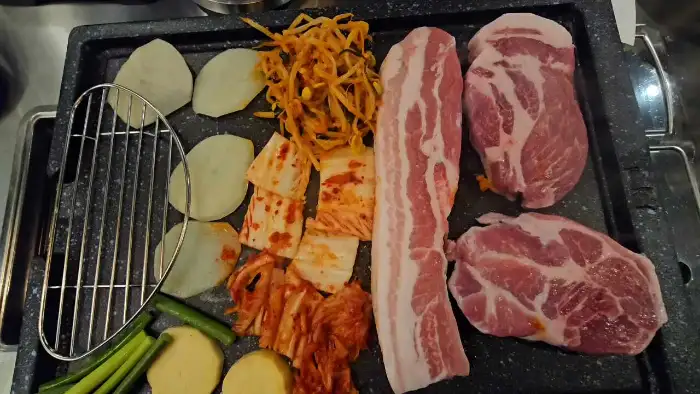 정갈하게 차려진 고기, 김치, 콩나물, 감자, 꽈리고추 등