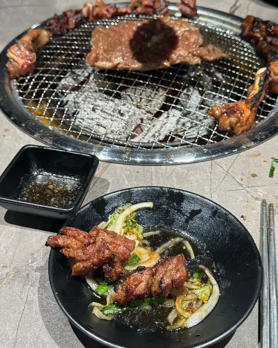 잘 구워진 갈비를 쌈에 싸 먹는 모습