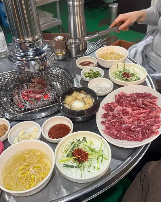 숯불 구이와 함께 다양한 반찬이 차려진 테이블 풍경