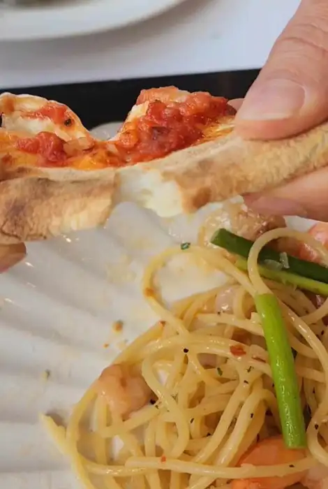 깔조네 조각을 파스타 소스에 찍어 먹는 모습