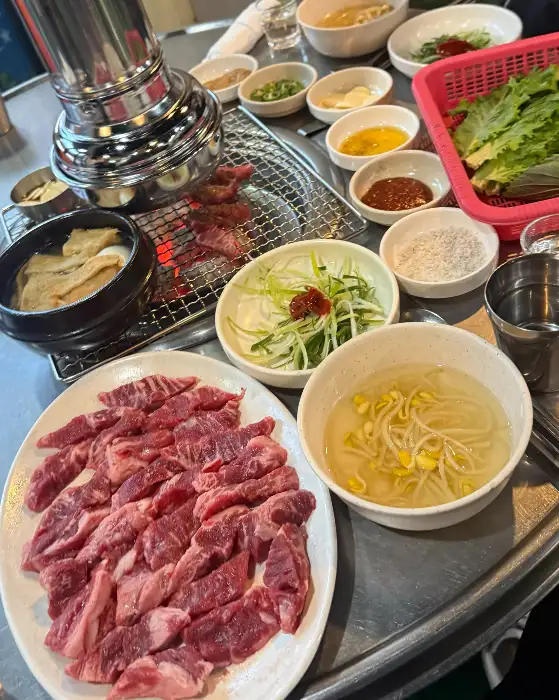 다양한 밑반찬과 콩나물 비빔밥, 그리고 고기 한상 차림