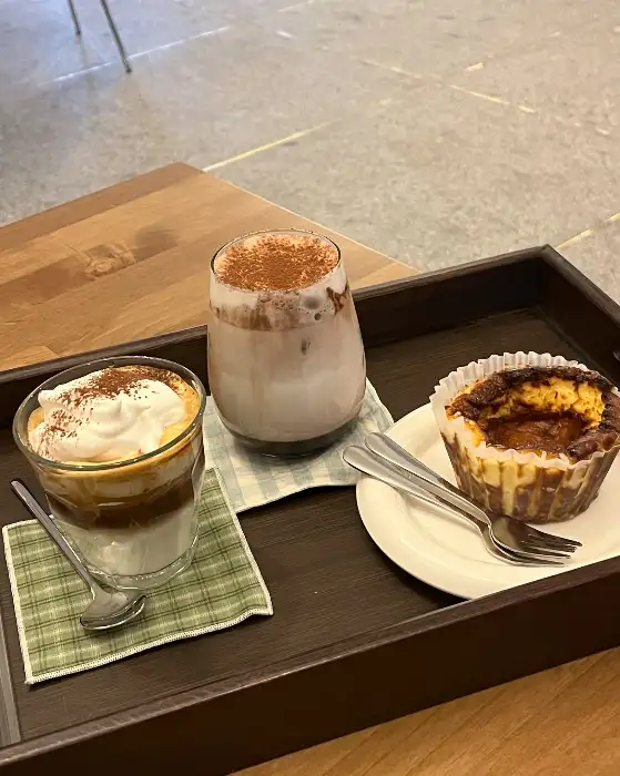 커피 위에 크림이 올라간 모습과 바스크 치즈 케이크