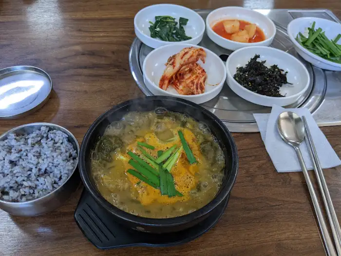 추어탕 한 그릇과 밥, 그리고 여러 가지 밑반찬이 차려진 모습