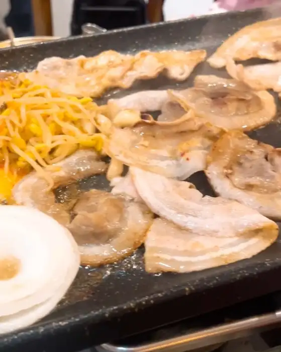 불판 위에서 익어가는 대패 삼겹살과 콩나물