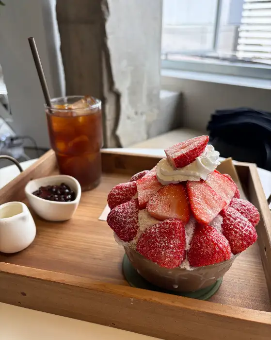 딸기로 뒤덮인 커다란 빙수와 아이스 아메리카노, 팥 그릇