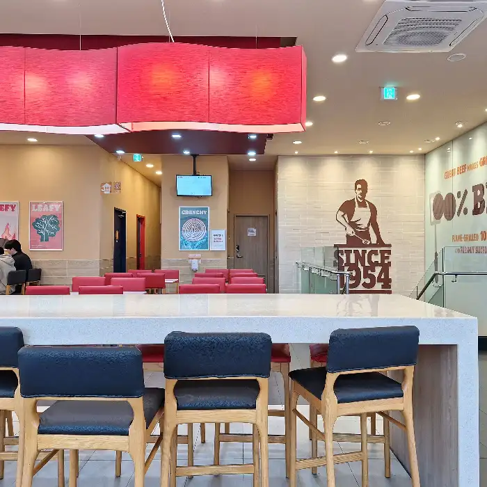 넓고 쾌적한 버거킹 매장 내부, 붉은 조명이 인상적인 테이블