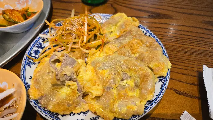 노릇하게 부쳐진 육전과 그 위에 파채가 올라가 있는 모습.