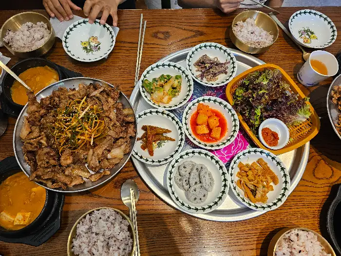 식탁 위에 차려진 여러 음식들과 밥, 놋그릇 등이 보인다.