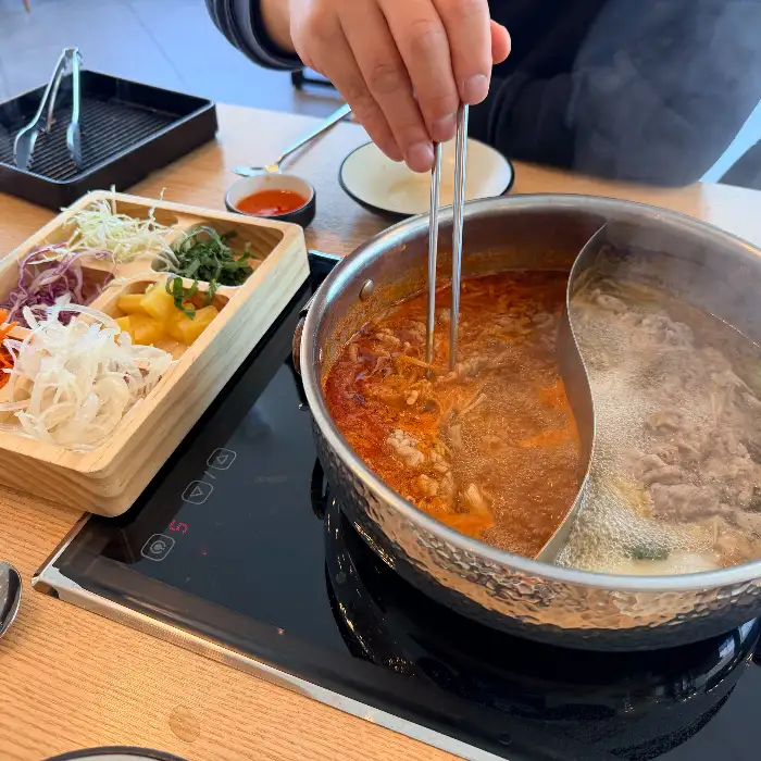 반반 육수가 끓고 있는 샤브샤브 냄비