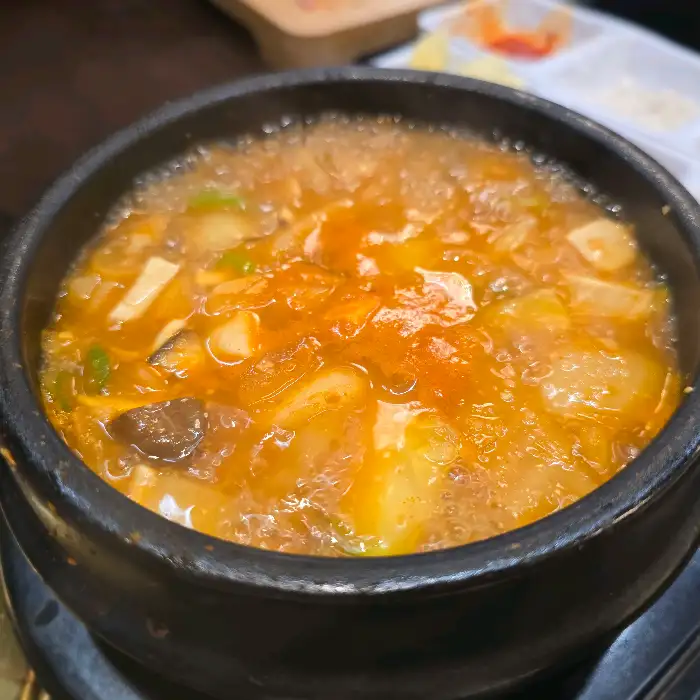 김치찌개 또는 된장찌개처럼 보이는 뚝배기 요리