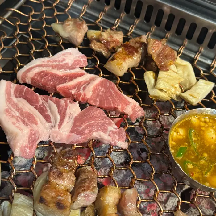 숯불 위에서 구워지는 다양한 부위의 돼지고기