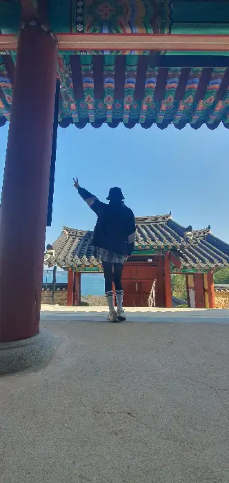 전통 건축물을 배경으로 서 있는 사람