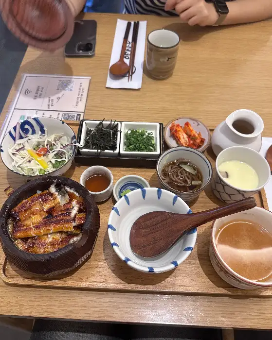 나무 트레이에 정갈하게 담긴 히츠마부시 정식 세트. 덮밥, 샐러드, 계란찜, 메밀국수, 국 등이 포함되어 있다.