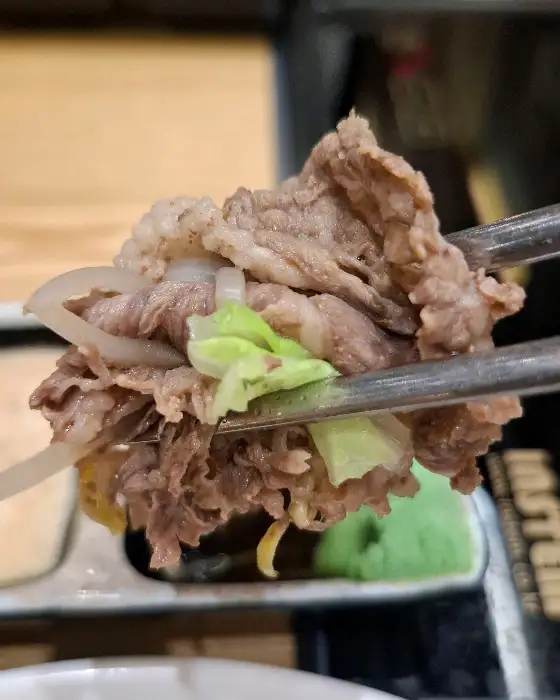 집게로 집어 올린 샤브샤브 고기