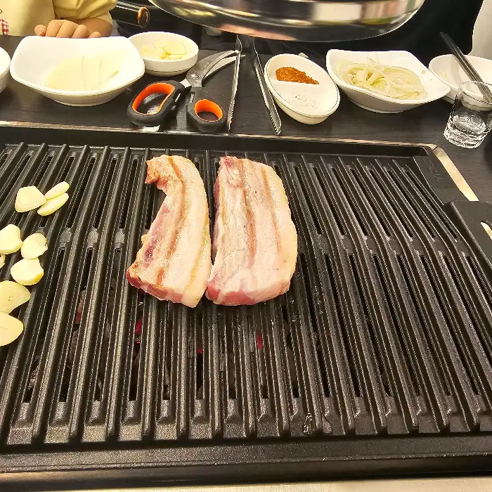 잘 구워진 삼겹살과 곁들임 반찬