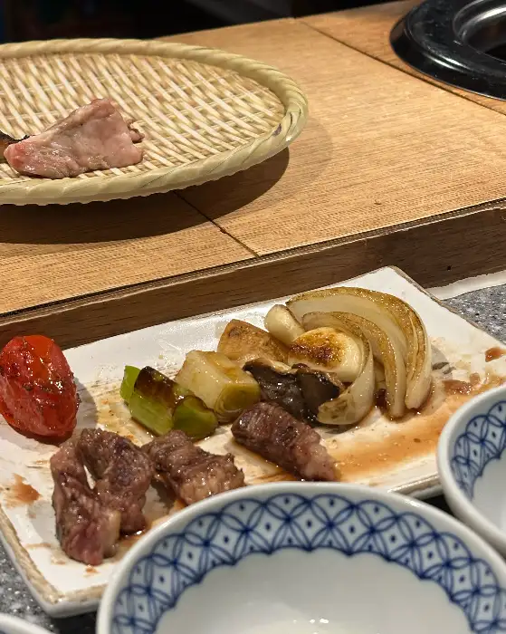잘 구워진 양갈비와 채소들이 접시에 담겨 있는 모습