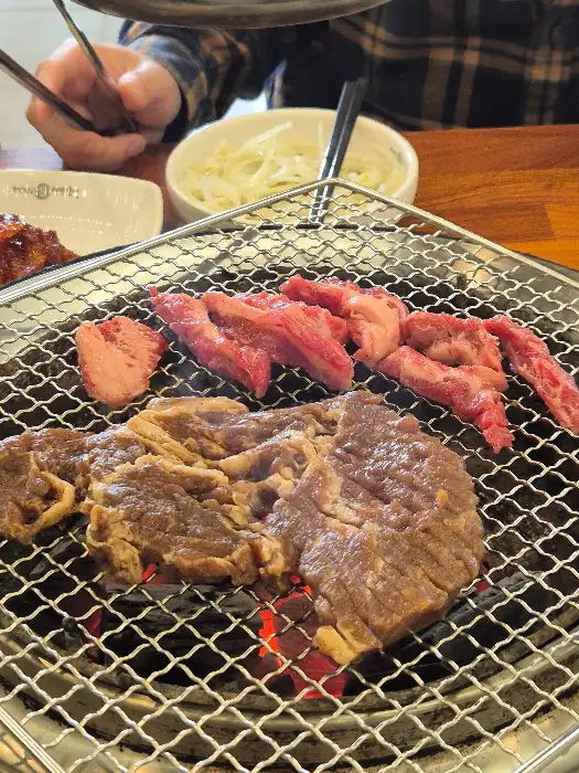 숯불 위에서 익어가는 돼지갈비와 냉면
