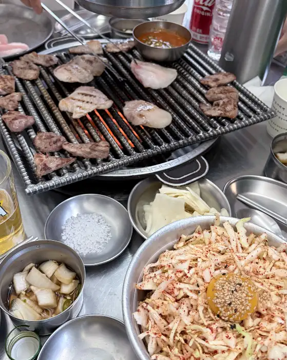 잘 구워진 돼지고기와 곁들임 반찬들