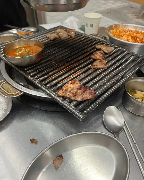 그릴 위에서 익어가며 연기를 내뿜는 돼지고기